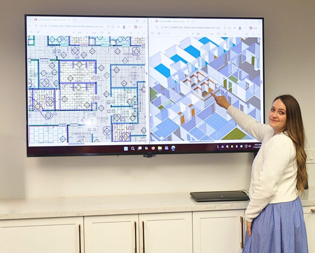 Woman demonstrating project details on large monitor